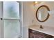 Bathroom with round rattan mirror, single sink, and frosted window for privacy at 2413 Buckhorn Run Dr, Valrico, FL 33596