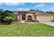 Charming single-story home with a well-manicured lawn, double-door entry, and a two-car garage at 2413 Buckhorn Run Dr, Valrico, FL 33596