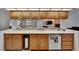 Well-lit kitchen bar overlooking the living room with a sink, dishwasher, and oak cabinets at 2413 Buckhorn Run Dr, Valrico, FL 33596