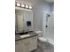Modern bathroom with granite countertops, white vanity, and walk-in shower with glass door at 2823 Banyan Hill Ln, Land O Lakes, FL 34639