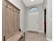 Inviting foyer with tiled floor, coat rack and bench seating upon entry at 2823 Banyan Hill Ln, Land O Lakes, FL 34639