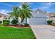 Charming single-story home featuring a two-car garage, well-maintained lawn, and beautiful palm trees at 2823 Banyan Hill Ln, Land O Lakes, FL 34639