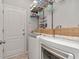 Functional laundry room with modern washer and dryer, storage baskets, and shelving for supplies at 2823 Banyan Hill Ln, Land O Lakes, FL 34639