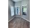 Bright room with wood-look flooring and large window showing views of outdoor space at 2823 Banyan Hill Ln, Land O Lakes, FL 34639