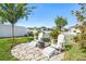 Backyard with a stone patio, four white Adirondack chairs and a fire pit at 34266 Radley Way, Wesley Chapel, FL 33545