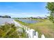 Backyard view with white picket fence surrounding pond at 34266 Radley Way, Wesley Chapel, FL 33545