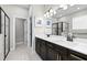 Contemporary bathroom featuring double sinks, a large mirror, sleek fixtures and separate shower room at 34266 Radley Way, Wesley Chapel, FL 33545