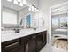 Bathroom featuring double sink vanity, a large mirror, modern fixtures and bedroom views at 34266 Radley Way, Wesley Chapel, FL 33545