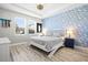 Stylish bedroom with crane-themed wallpaper, tray ceiling, and neutral furniture, offering a serene retreat at 34266 Radley Way, Wesley Chapel, FL 33545