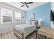 Bedroom featuring a large window, blue accent wall, beach-themed decor, and a study space at 34266 Radley Way, Wesley Chapel, FL 33545