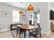 Bright dining area featuring modern lighting, a wooden table with seating for four, and sliding glass doors at 34266 Radley Way, Wesley Chapel, FL 33545