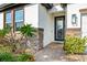 Up-close view of a home's front entrance highlighting its stone accents, brick pathway, and lush landscaping at 34266 Radley Way, Wesley Chapel, FL 33545