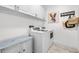 Bright laundry room boasts tile flooring, a washer and dryer set, and ample cabinet space at 34266 Radley Way, Wesley Chapel, FL 33545