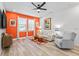 Comfortable living room featuring vibrant accent wall, modern furniture, and ample natural light from the windows at 34266 Radley Way, Wesley Chapel, FL 33545