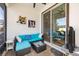 Screened patio with blue cushioned wicker seating and view to interior living room through sliding glass door at 34266 Radley Way, Wesley Chapel, FL 33545