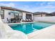 Backyard pool with a white patio, lounge chairs, dining table, and an umbrella offers an enjoyable outdoor area at 34266 Radley Way, Wesley Chapel, FL 33545