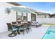 Backyard pool area features outdoor dining area and chaise lounges for relaxing by the pool at 34266 Radley Way, Wesley Chapel, FL 33545