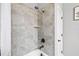 Shower with a tile surround, shower head, and a soap and shampoo shelf for convenience at 34266 Radley Way, Wesley Chapel, FL 33545