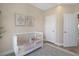 Bright bedroom features a crib, accent rug, lots of sunlight from the large window, and neutral walls at 4139 Rocky Shores Dr, Tampa, FL 33634