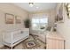 Bright bedroom features a crib, accent rug, lots of sunlight from the large window, and neutral walls at 4139 Rocky Shores Dr, Tampa, FL 33634