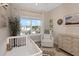 Bright bedroom features a crib, accent rug, lots of sunlight from the large window, and neutral walls at 4139 Rocky Shores Dr, Tampa, FL 33634