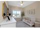 Bright bedroom features a crib, accent rug, lots of sunlight from the large window, and neutral walls at 4139 Rocky Shores Dr, Tampa, FL 33634