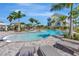 A sparkling community pool surrounded by lush greenery, palm trees, and comfortable lounge chairs at 4139 Rocky Shores Dr, Tampa, FL 33634