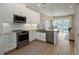 Open kitchen with stainless steel appliances and white cabinets, next to the dining and living areas at 4139 Rocky Shores Dr, Tampa, FL 33634