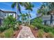 Scenic walkway adorned with vibrant greenery and flowers between residential homes, enhancing the neighborhood's charm at 4139 Rocky Shores Dr, Tampa, FL 33634