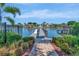 A picturesque waterfront view with a wooden dock, serene water, and lush landscaping at 4139 Rocky Shores Dr, Tampa, FL 33634