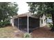 Side view of the house featuring a screened-in porch with a concrete tile patio at 4214 Longfellow Dr, Plant City, FL 33566