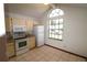 A kitchen with a white refrigerator, stove, microwave, tile flooring, and a large window at 4214 Longfellow Dr, Plant City, FL 33566
