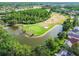 An aerial view shows a lush golf course surrounded by beautiful trees and water features in a residential community at 4227 Sandy Shores Dr, Lutz, FL 33558