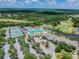 This is an aerial shot of a community clubhouse with tennis courts, a pool, and a golf course, all amid lush landscaping at 4227 Sandy Shores Dr, Lutz, FL 33558