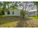 Exterior view of home with a screened-in lanai with mature landscaping and a tree in the backyard at 4227 Sandy Shores Dr, Lutz, FL 33558
