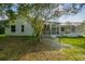 Exterior view of home with a screened-in lanai with mature landscaping and a tree in the backyard at 4227 Sandy Shores Dr, Lutz, FL 33558