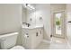 Modern bathroom featuring white cabinets, quartz countertop, sleek fixtures, and access to the outdoors at 4227 Sandy Shores Dr, Lutz, FL 33558