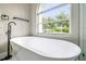 Modern bathroom features a freestanding tub with a window view and black fixtures at 4227 Sandy Shores Dr, Lutz, FL 33558