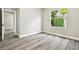 Bright bedroom with wood-look flooring and a window offering a pleasant view of lush greenery at 4227 Sandy Shores Dr, Lutz, FL 33558