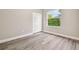 Cozy bedroom with wood-look floors, a double-door closet, and a sunny window showcasing lush greenery at 4227 Sandy Shores Dr, Lutz, FL 33558