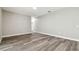 An empty room with grey wood floors and white trim offers a neutral canvas for personalization and decor at 4227 Sandy Shores Dr, Lutz, FL 33558