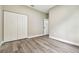 Neutral bedroom featuring vinyl floors, closet with bi-fold doors, and a doorway leading to another room at 4227 Sandy Shores Dr, Lutz, FL 33558