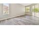 Bedroom featuring two windows offering natural light and wood flooring at 4227 Sandy Shores Dr, Lutz, FL 33558