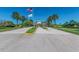 Entrance to a community featuring palm trees and manicured lawns on either side at 4227 Sandy Shores Dr, Lutz, FL 33558