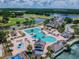 Aerial view featuring a large community pool, clubhouse, and golf course with a lake in the background at 4227 Sandy Shores Dr, Lutz, FL 33558