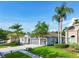 A well-manicured front yard with a lush green lawn, mature landscaping, and palm trees at 4227 Sandy Shores Dr, Lutz, FL 33558