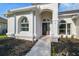 Inviting home entrance featuring arched windows, a decorative front door, and manicured landscaping at 4227 Sandy Shores Dr, Lutz, FL 33558