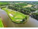 Scenic aerial view of a pristine island golf green and sand traps along a lake at 4227 Sandy Shores Dr, Lutz, FL 33558