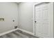 A laundry room with gray wood floors and white painted walls with hookups ready for a washer and dryer at 4227 Sandy Shores Dr, Lutz, FL 33558