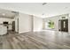 Open-concept living area with wood-look flooring, natural light, and adjacent kitchen at 4227 Sandy Shores Dr, Lutz, FL 33558